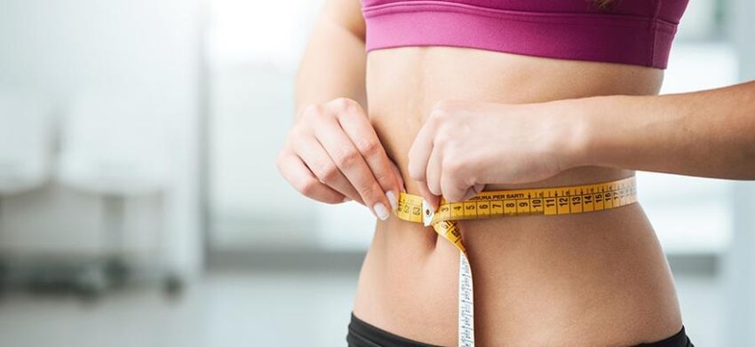 A girl measures her waist size